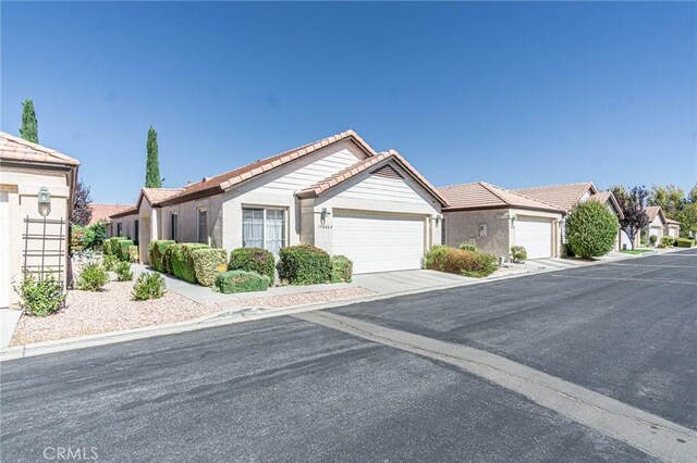 19046 Stoddard Way, Apple Valley, CA 92308 - ranch-style home with a tile roof, a garage, and stucco siding