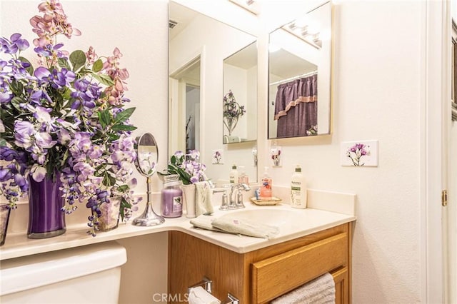 bathroom featuring vanity and toilet