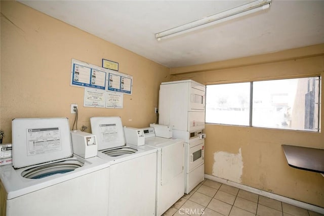 washroom with light tile patterned floors, stacked washer / dryer, and washing machine and clothes dryer