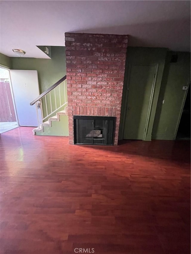 unfurnished living room with a fireplace and hardwood / wood-style flooring