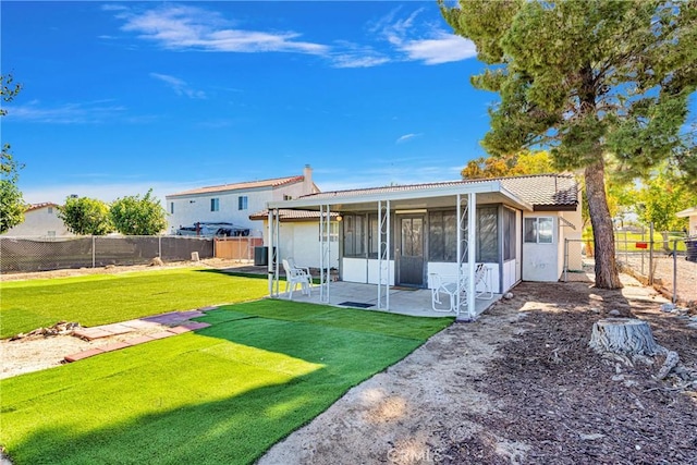 back of house with a patio, a lawn, and a sunroom