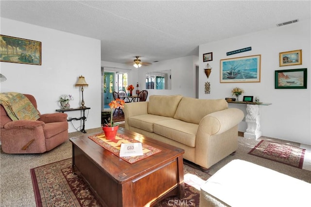 carpeted living room featuring a textured ceiling and ceiling fan