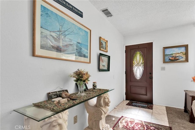 carpeted foyer entrance featuring a textured ceiling