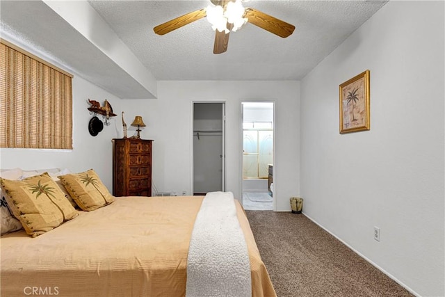 bedroom featuring ensuite bath, carpet flooring, a spacious closet, a textured ceiling, and a closet