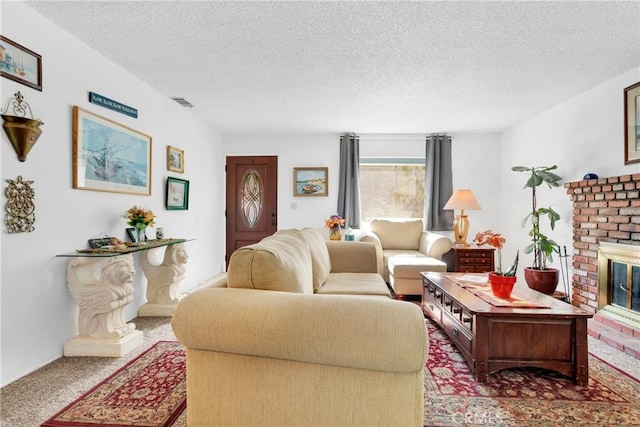 living room with a textured ceiling and a brick fireplace