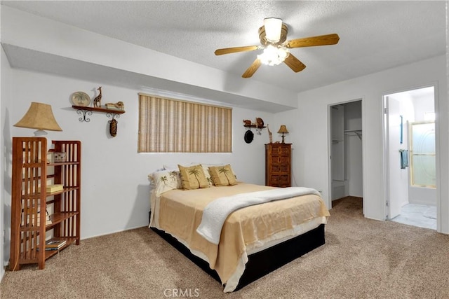 carpeted bedroom with connected bathroom, ceiling fan, a spacious closet, a textured ceiling, and a closet