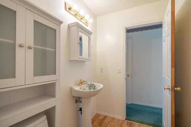 bathroom with toilet and hardwood / wood-style flooring