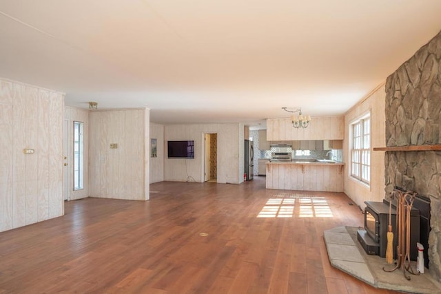 unfurnished living room with a chandelier and light wood-type flooring