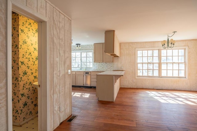 kitchen with light wood-type flooring, an inviting chandelier, a healthy amount of sunlight, and sink