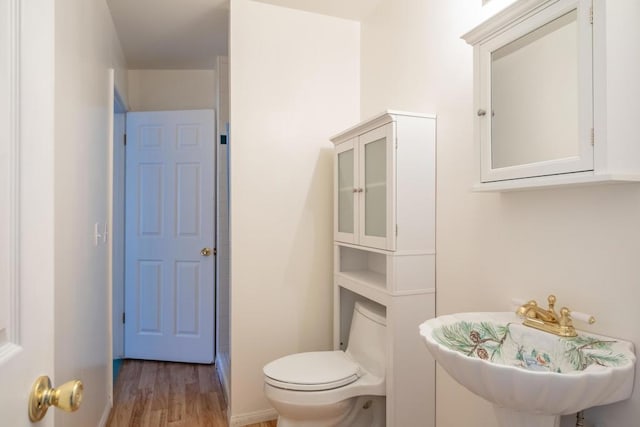 bathroom with sink, wood-type flooring, and toilet