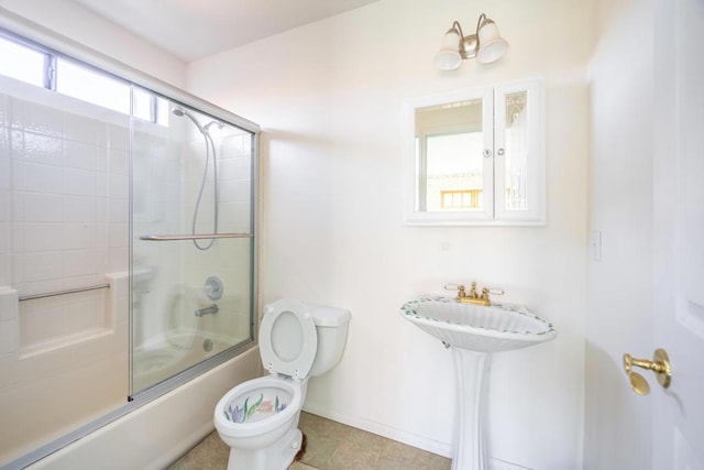 full bathroom with toilet, sink, and shower / bath combination with glass door