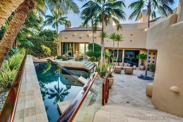 view of pool featuring a patio area, an outdoor living space, and an in ground hot tub