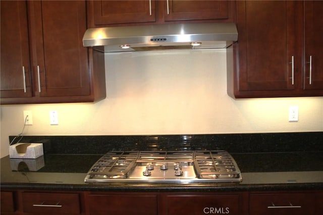 kitchen with dark stone countertops and stainless steel gas stovetop