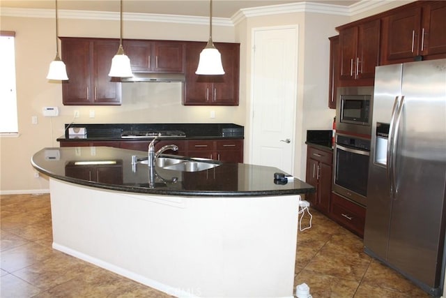 kitchen with stainless steel appliances, crown molding, sink, decorative light fixtures, and a center island with sink