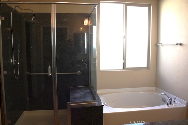 bathroom featuring separate shower and tub