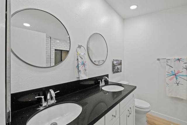 bathroom featuring toilet, vanity, and hardwood / wood-style floors