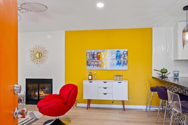 sitting room with light hardwood / wood-style floors and a large fireplace