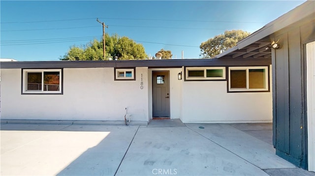 view of exterior entry with a patio