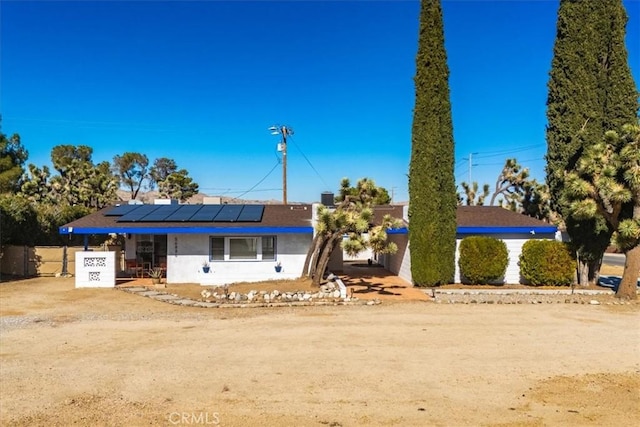 single story home featuring solar panels