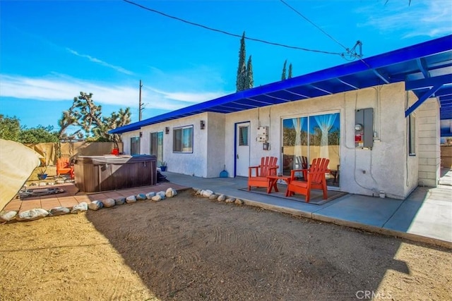 view of front of property featuring electric panel, a patio, and a hot tub