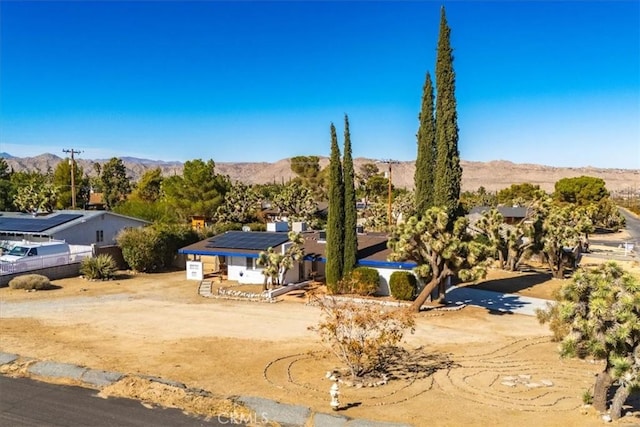 view of front of property featuring solar panels and a mountain view