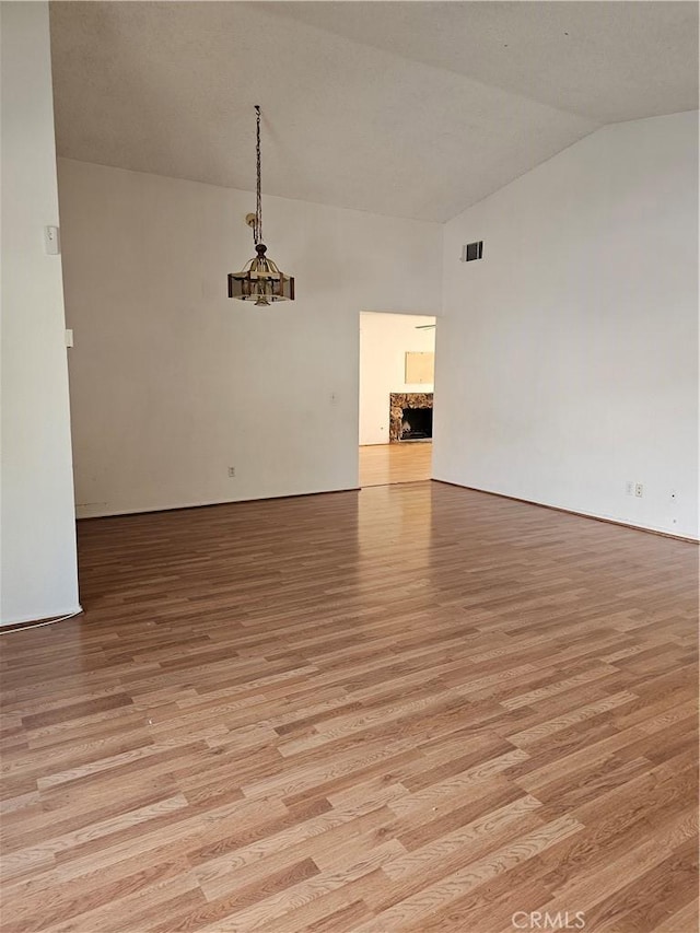 spare room featuring light hardwood / wood-style floors and lofted ceiling