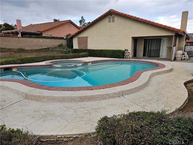 view of swimming pool featuring an in ground hot tub and a patio