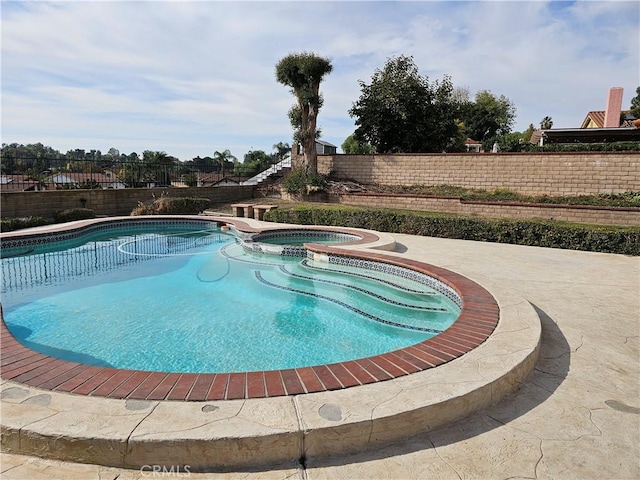 view of swimming pool featuring an in ground hot tub and a patio