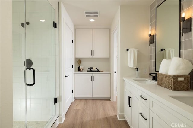 bathroom featuring vanity, wood-type flooring, and an enclosed shower