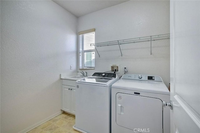 clothes washing area with sink, cabinets, and independent washer and dryer