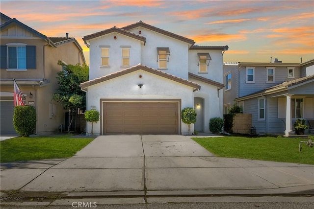 mediterranean / spanish-style home with a garage and a lawn