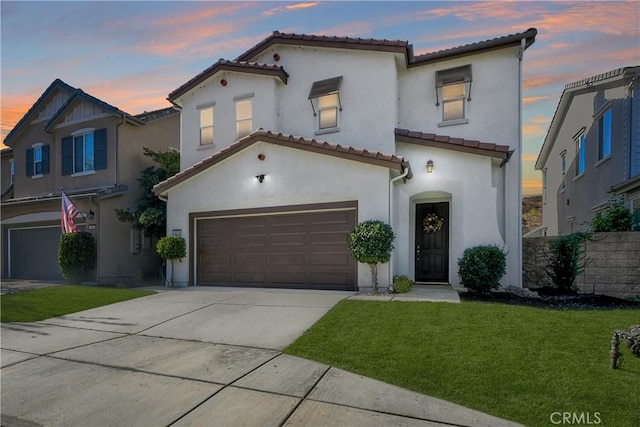 mediterranean / spanish house featuring a garage and a yard