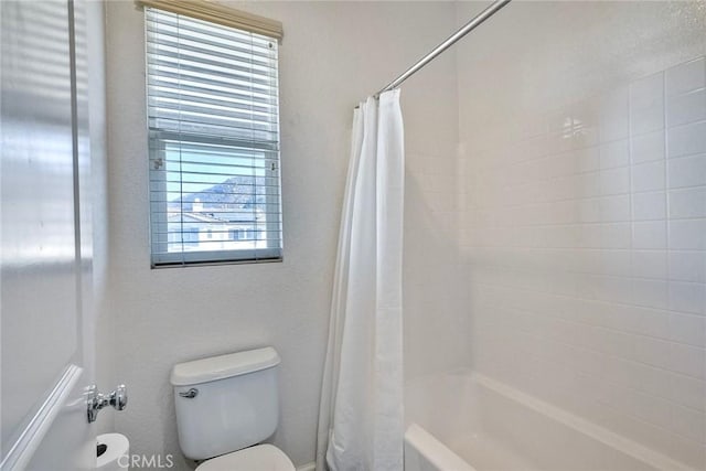 bathroom with shower / tub combo with curtain and toilet