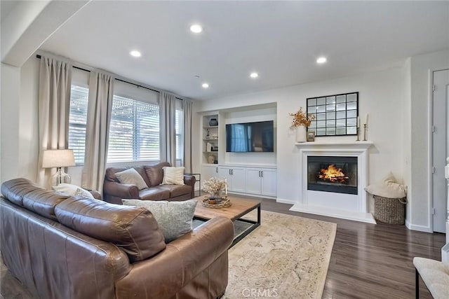 living room featuring built in shelves and dark hardwood / wood-style floors