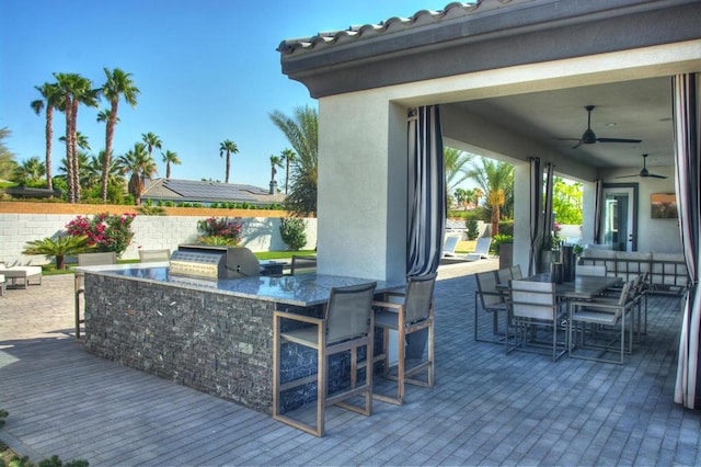 wooden terrace featuring ceiling fan, a grill, a bar, and a patio