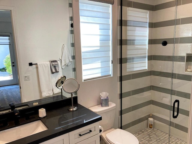 bathroom featuring toilet, an enclosed shower, and vanity