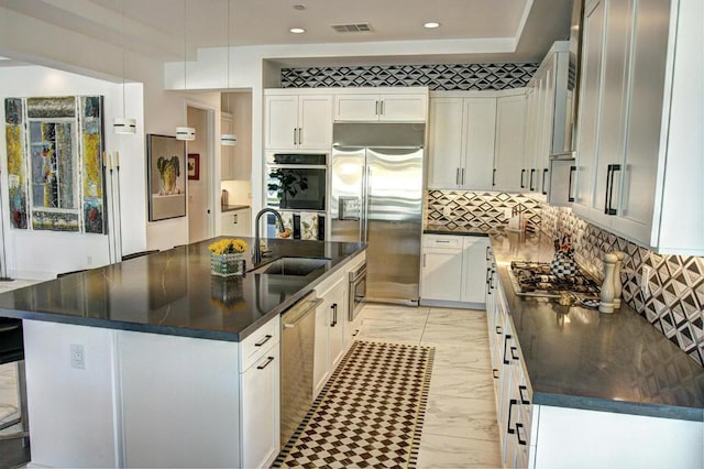 kitchen with sink, white cabinets, a center island with sink, and stainless steel appliances