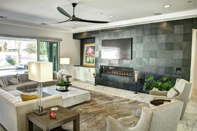 living room with ceiling fan and a tiled fireplace