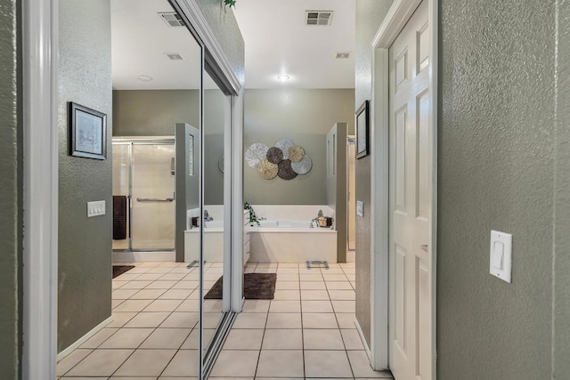 bathroom with tile patterned floors and shower with separate bathtub