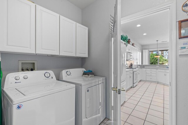 washroom featuring light tile patterned flooring, cabinets, and independent washer and dryer