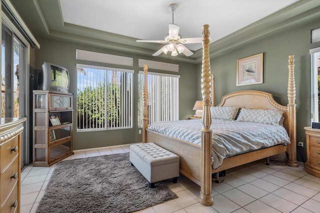 bedroom with light tile patterned floors, a raised ceiling, and ceiling fan