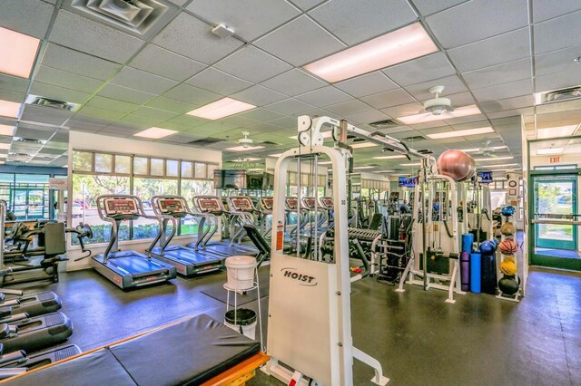 gym featuring ceiling fan and a drop ceiling