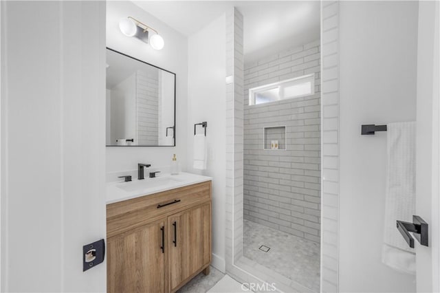 bathroom with vanity and a tile shower