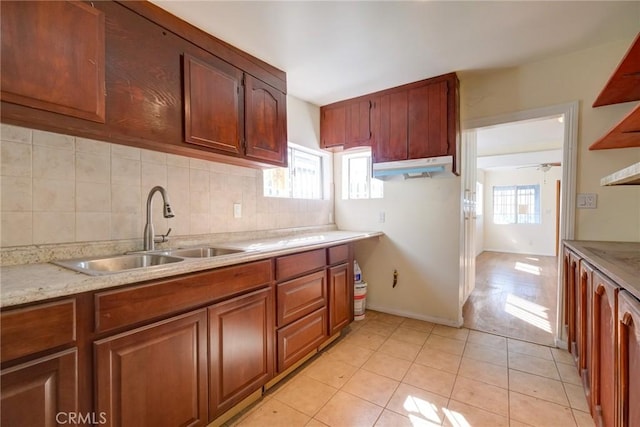 kitchen with light tile patterned floors, backsplash, ceiling fan, and sink