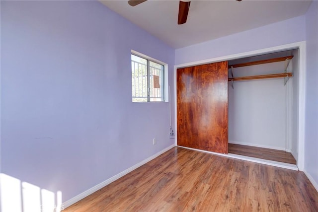 unfurnished bedroom with ceiling fan, a closet, and wood-type flooring