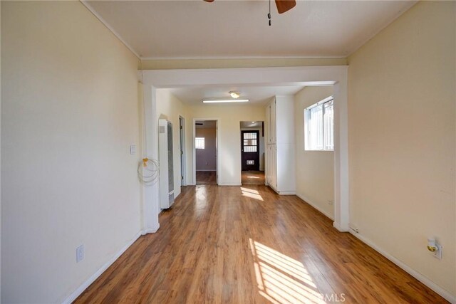 empty room with ceiling fan and light hardwood / wood-style flooring