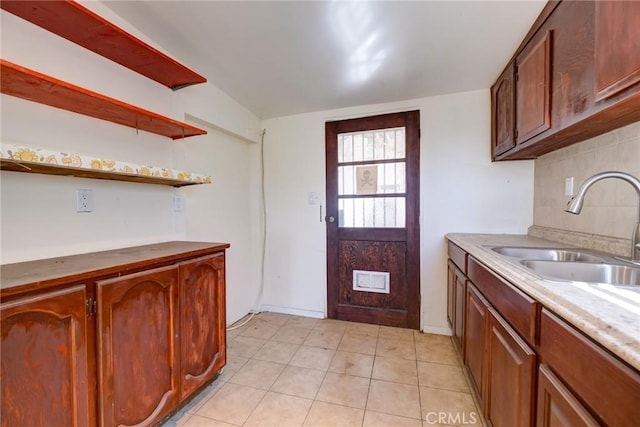 kitchen with backsplash, light tile patterned floors, and sink