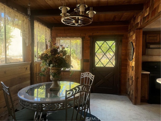 dining room with beamed ceiling, wood walls, wood ceiling, and an inviting chandelier