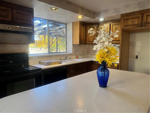 kitchen featuring tasteful backsplash, sink, black appliances, and a textured ceiling