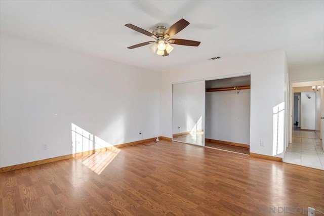 unfurnished bedroom featuring ceiling fan, a closet, and light hardwood / wood-style floors